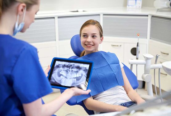 Zahnarztkundin erwartet Röntgenbild vom eigenen Kiefer von Zahnärztin